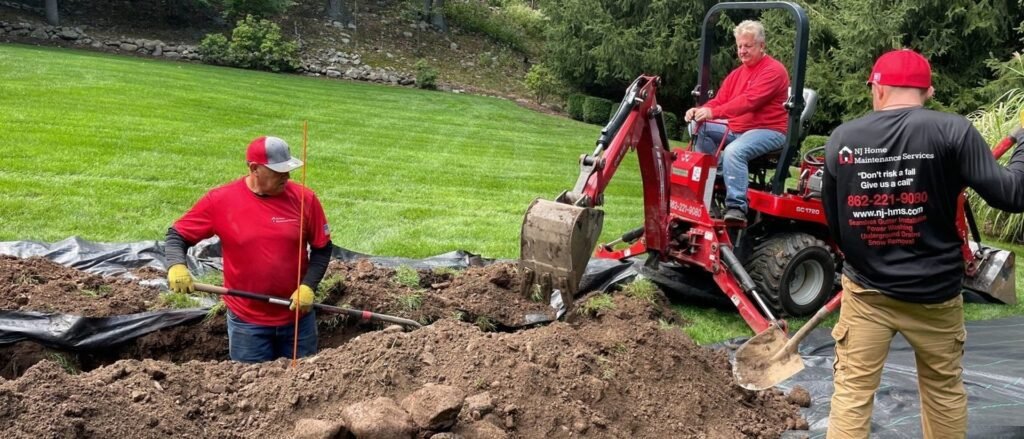 NJ Home Maintenance Services crew with a mini excavator installing an underground drainage system in Franklin Lakes, NJ