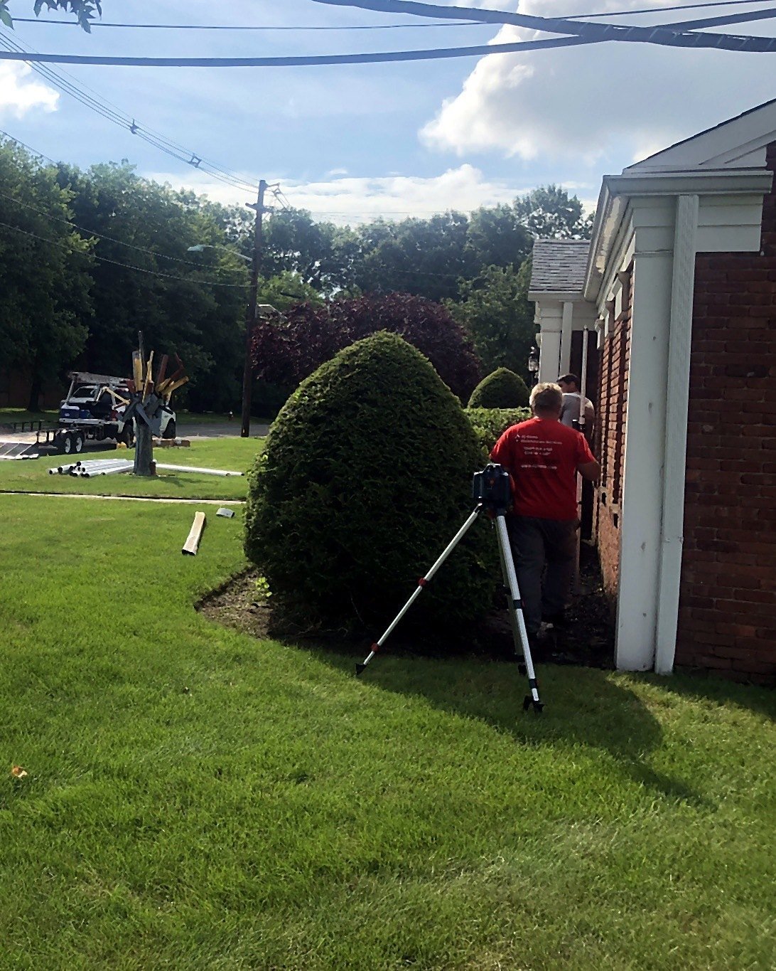 NJHMS technician using a transit level before a drain installation in Fairfield, NJ